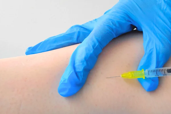 biopuntura inyectando con guantes y aguja pequena